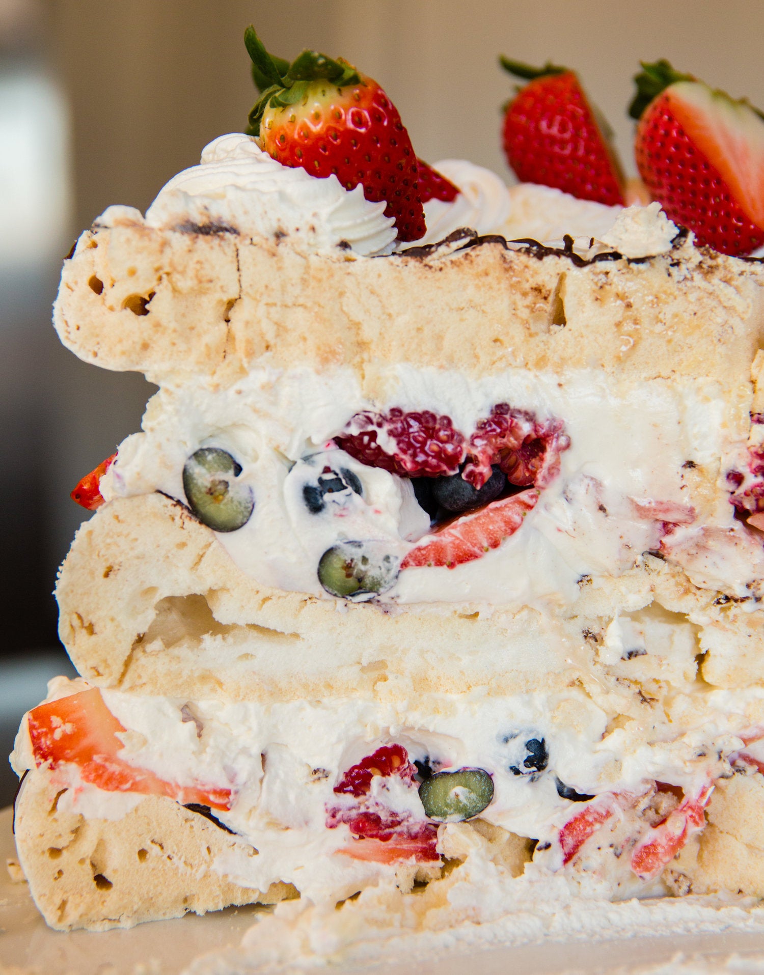 Half of the Boccone Dolce, with layers of chocolate-drizzled meringue, whipped cream, and fresh berries