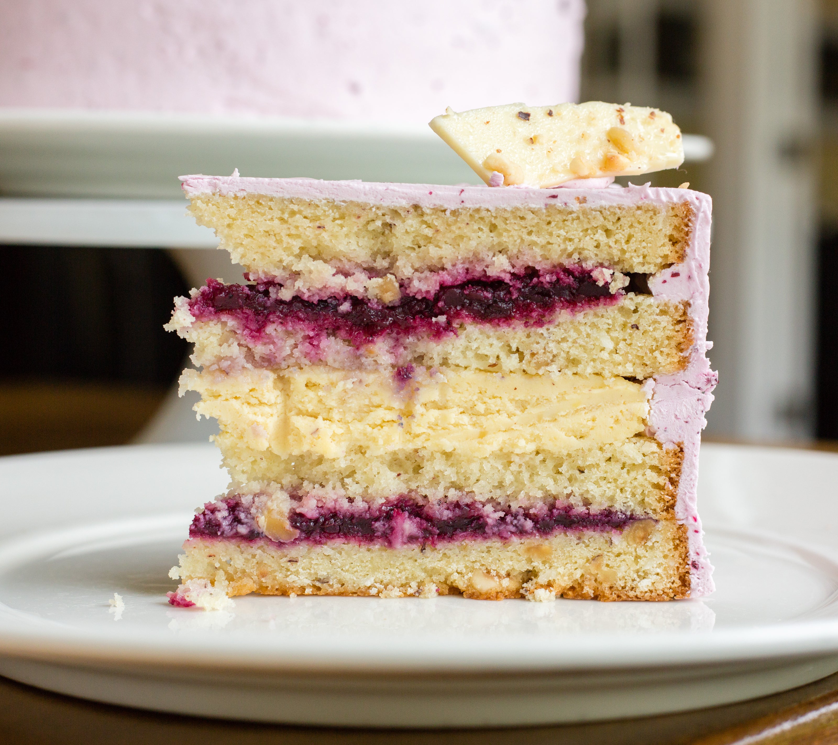 A slice of the Mt. Adams cake from Papa Haydn, with layers of hazelnut-coconut cake, praline Viennese buttercream, and wild huckleberry compote, finished with huckleberry buttercream