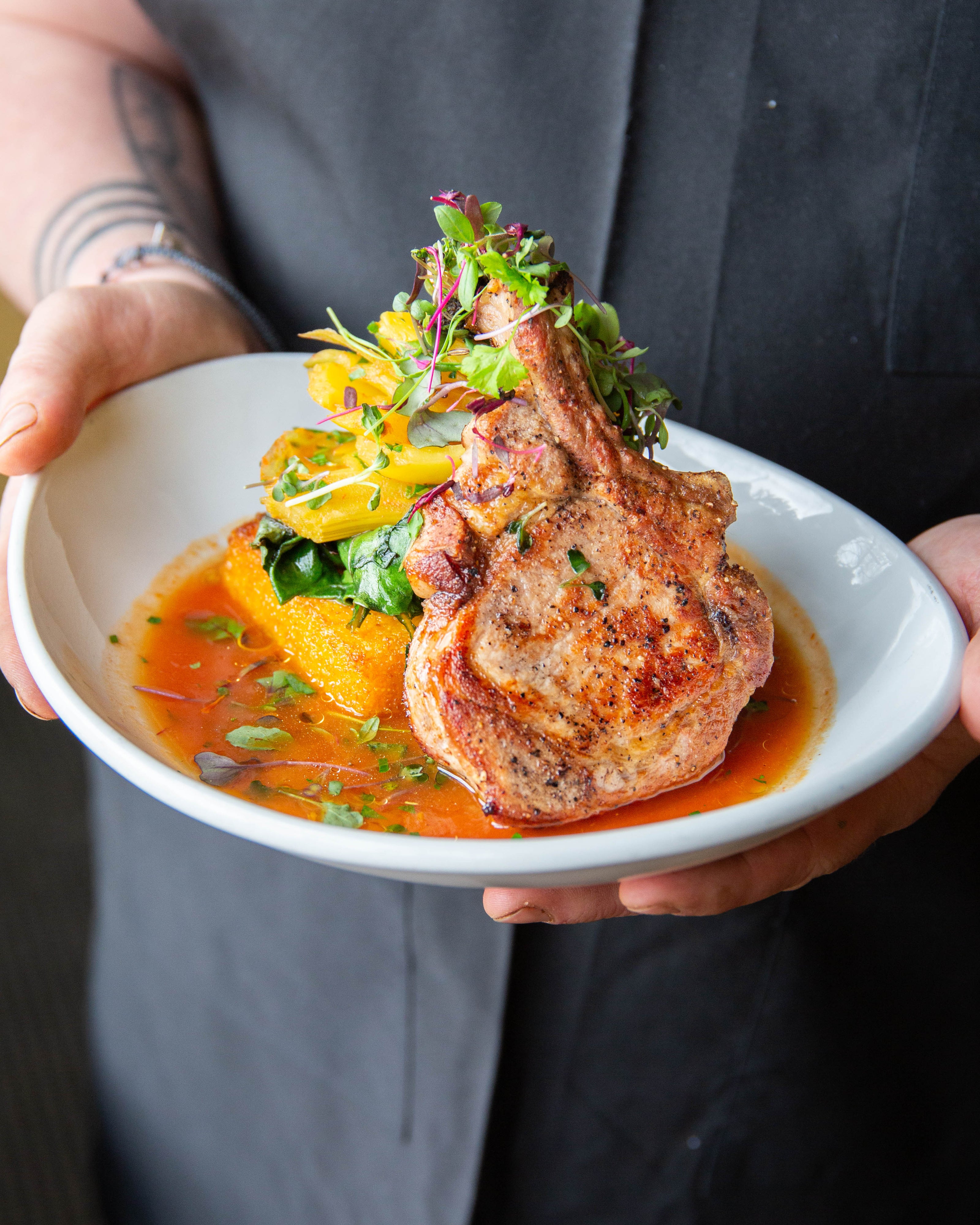 A pork dish on the dinner menu at Papa Haydn's Sellwood restaurant with a polenta cake, greens, and squash