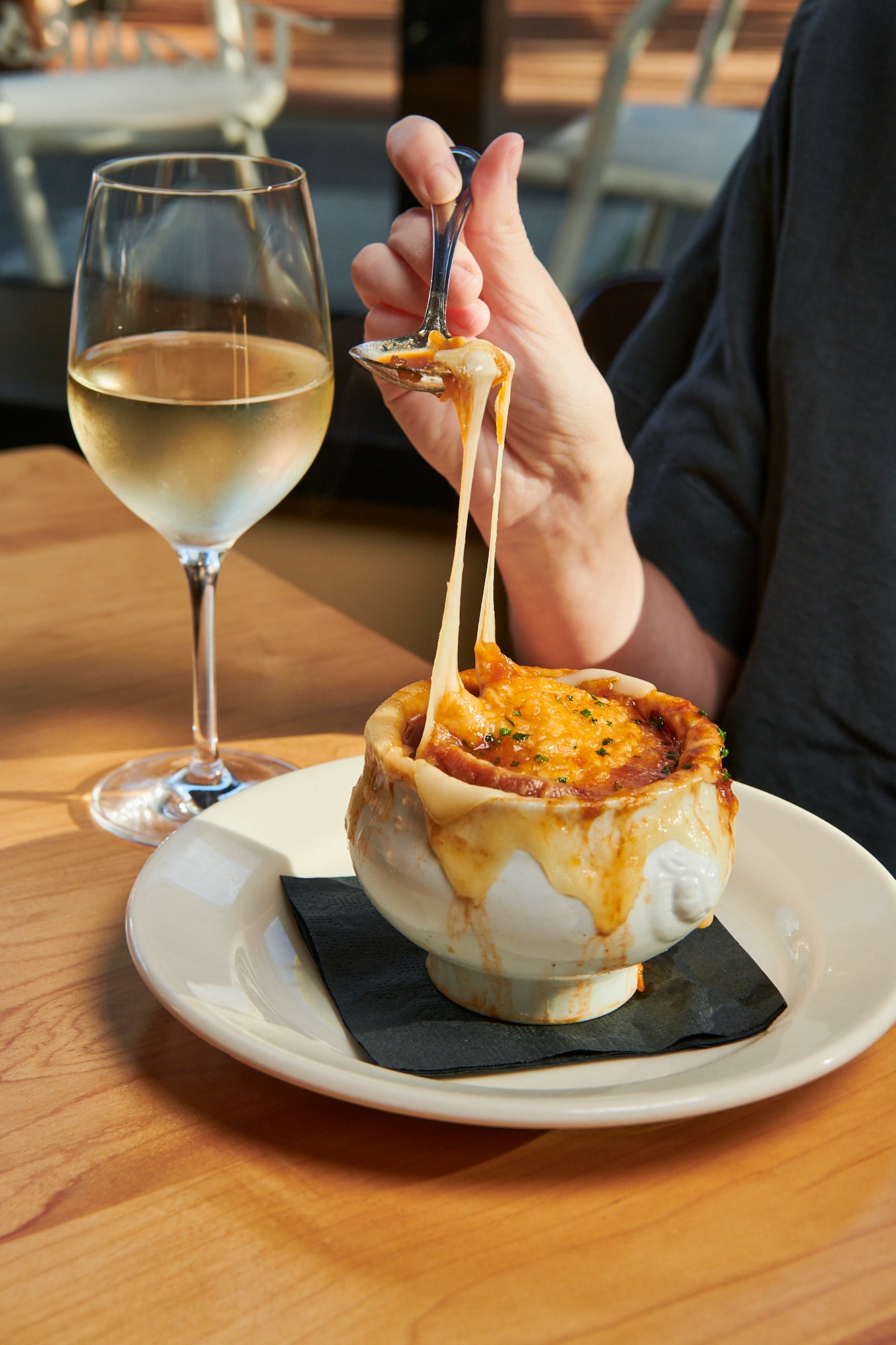 A bowl of Papa Haydn's French Onion Soup and a glass of white wine